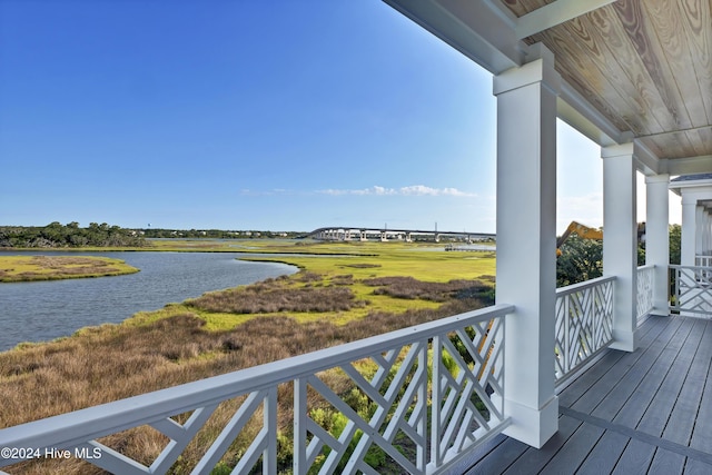 balcony with covered porch and a water view