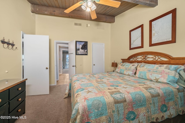 carpeted bedroom featuring visible vents, beamed ceiling, wood ceiling, and a ceiling fan