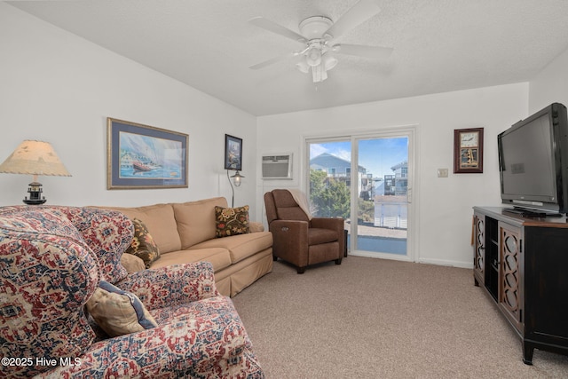 living area featuring light carpet, baseboards, ceiling fan, a wall mounted air conditioner, and a textured ceiling