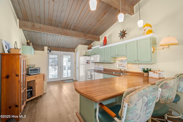 kitchen with lofted ceiling with beams, a peninsula, white appliances, a sink, and green cabinetry