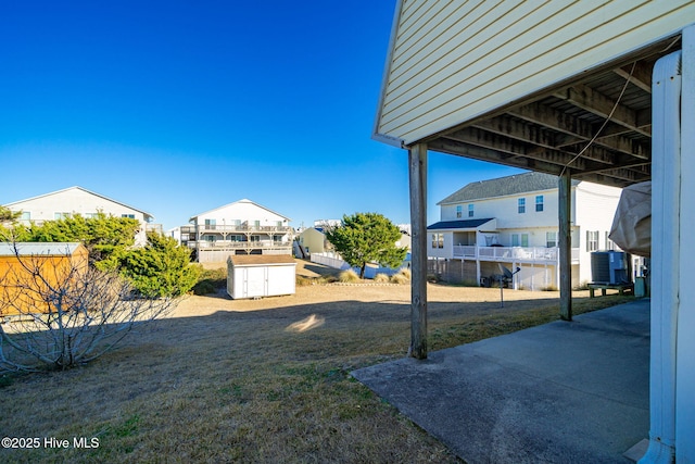 view of yard with an outbuilding, a shed, central AC unit, and a residential view