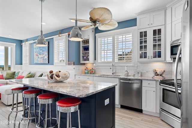 kitchen featuring a center island, sink, white cabinets, and appliances with stainless steel finishes