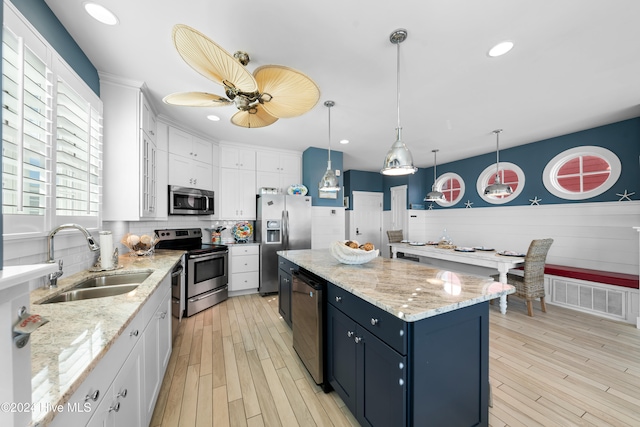 kitchen with white cabinetry, sink, decorative light fixtures, and appliances with stainless steel finishes