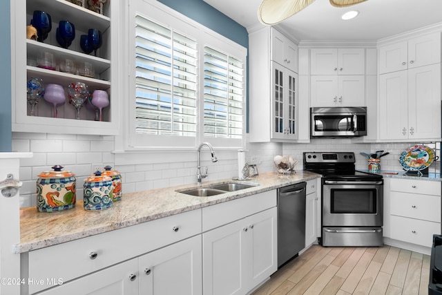 kitchen with decorative backsplash, white cabinetry, sink, and appliances with stainless steel finishes