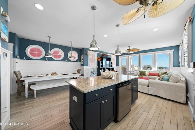 kitchen featuring light stone countertops, pendant lighting, light hardwood / wood-style flooring, and a kitchen island