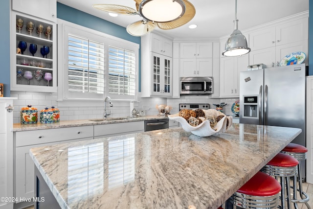 kitchen featuring pendant lighting, a kitchen island, sink, and stainless steel appliances