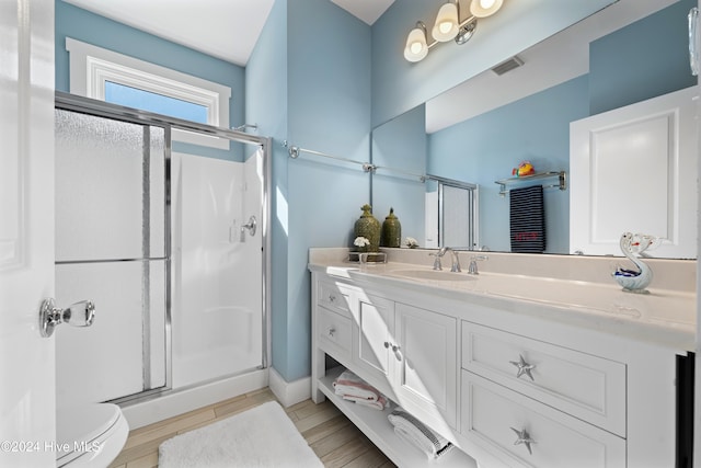 bathroom featuring toilet, vanity, wood-type flooring, and walk in shower