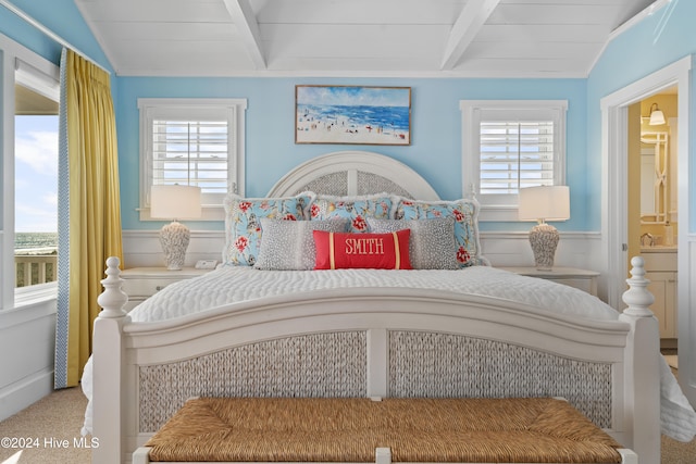 bedroom featuring multiple windows, carpet, and vaulted ceiling with beams