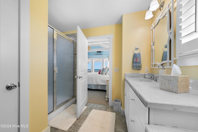 bathroom featuring a shower with door, vanity, and tile patterned flooring