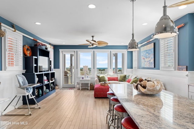 living room with ceiling fan and light hardwood / wood-style flooring