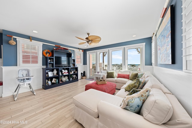 living room featuring ceiling fan and light hardwood / wood-style flooring