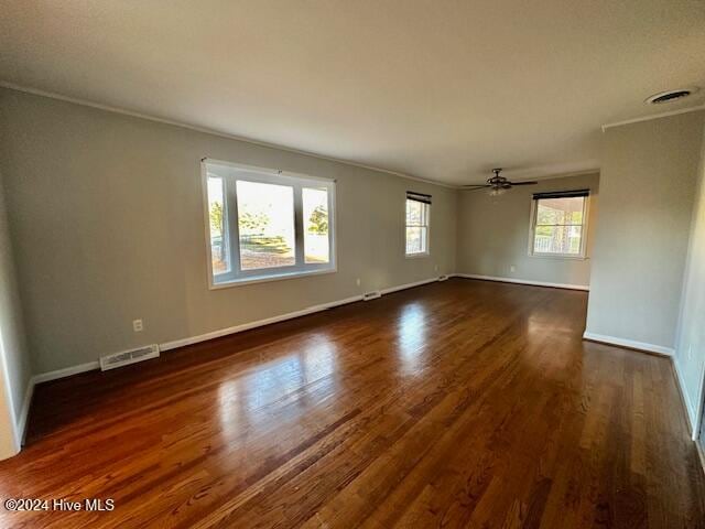 unfurnished room featuring dark hardwood / wood-style floors, plenty of natural light, crown molding, and ceiling fan