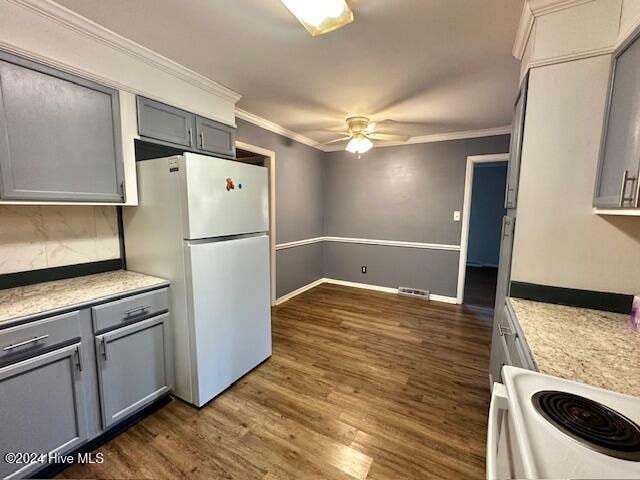 kitchen with gray cabinetry, crown molding, dark hardwood / wood-style flooring, and white appliances