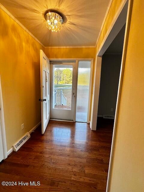 entryway featuring dark hardwood / wood-style flooring, an inviting chandelier, and ornamental molding