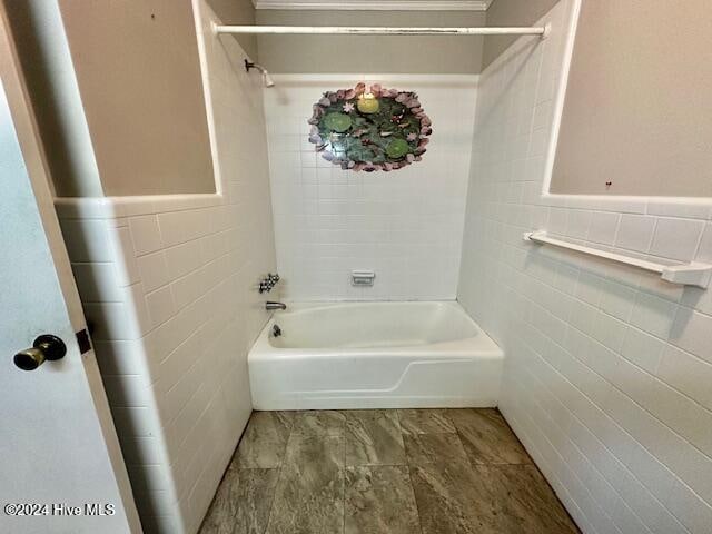 bathroom with bathing tub / shower combination and tile walls