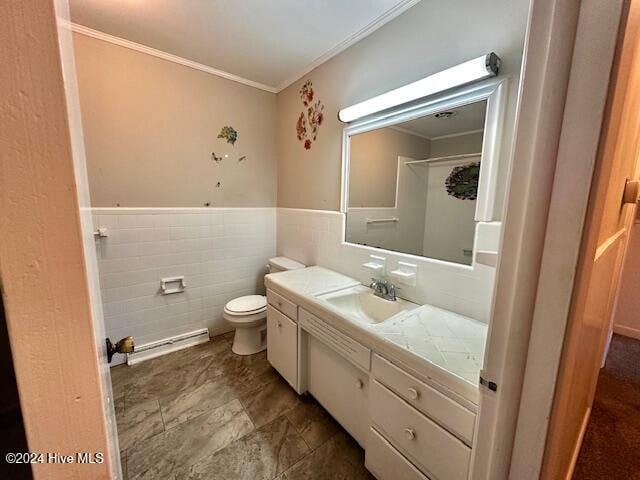 bathroom with vanity, toilet, ornamental molding, and tile walls