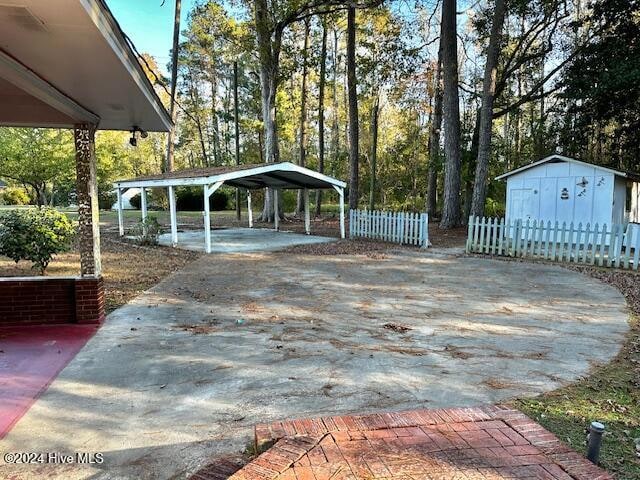 view of patio featuring a storage unit and a carport