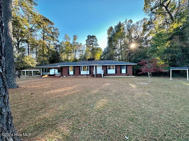 ranch-style home with a front yard and a carport