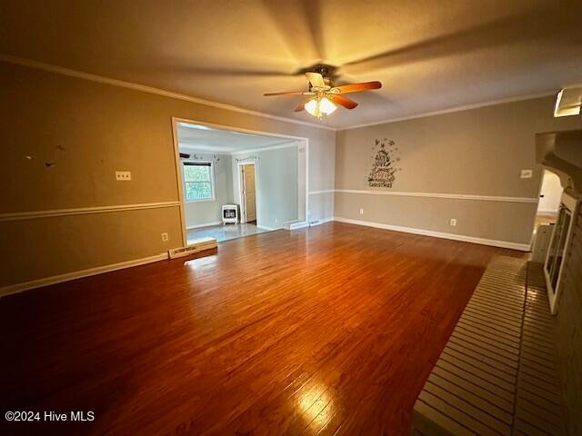 unfurnished living room featuring ceiling fan, wood-type flooring, and crown molding