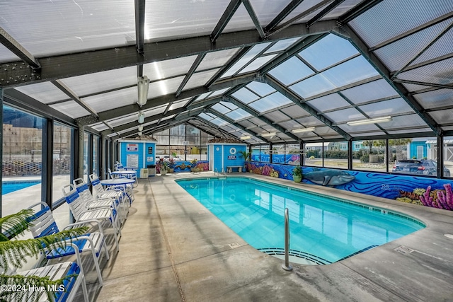 view of swimming pool with glass enclosure and a patio area