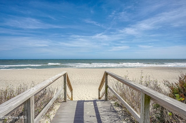 surrounding community with a water view and a view of the beach