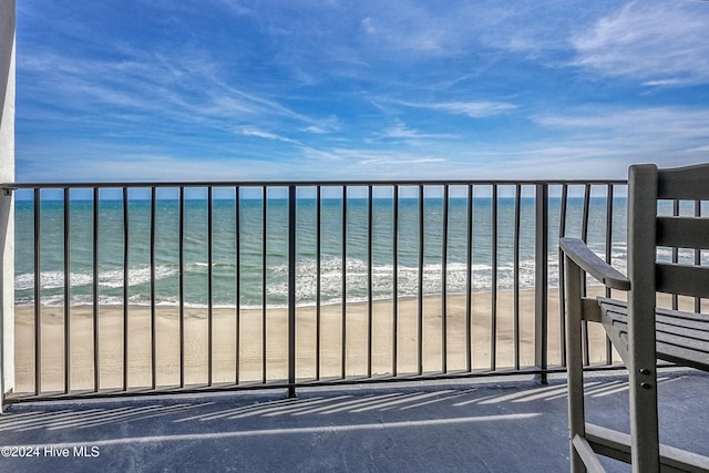 balcony featuring a water view and a beach view