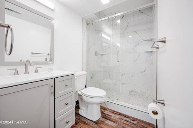 bathroom with hardwood / wood-style flooring, vanity, toilet, and an enclosed shower