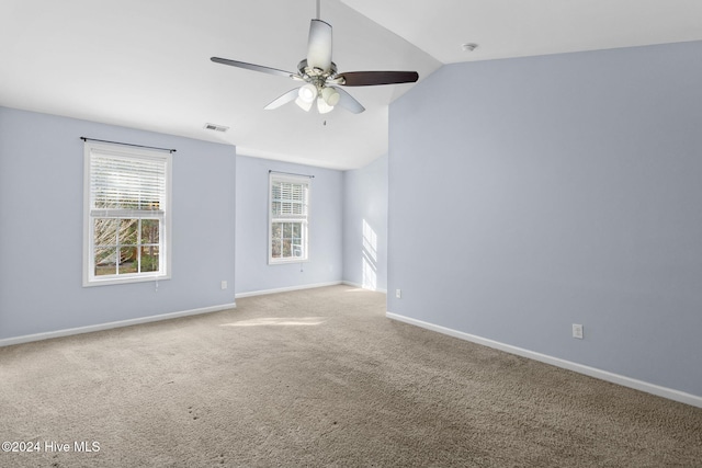 carpeted spare room featuring ceiling fan and lofted ceiling