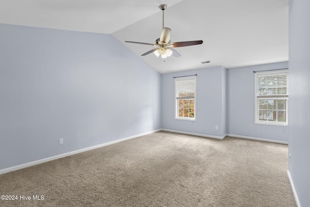 carpeted spare room featuring ceiling fan and lofted ceiling