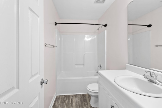 full bathroom featuring washtub / shower combination, hardwood / wood-style floors, vanity, and toilet