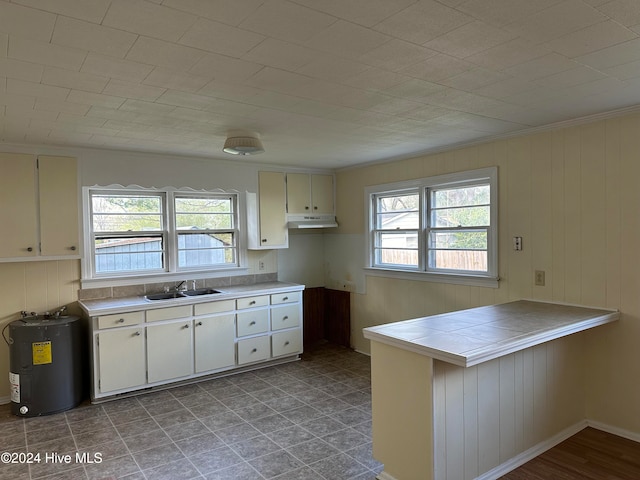 kitchen featuring a healthy amount of sunlight, kitchen peninsula, sink, and water heater