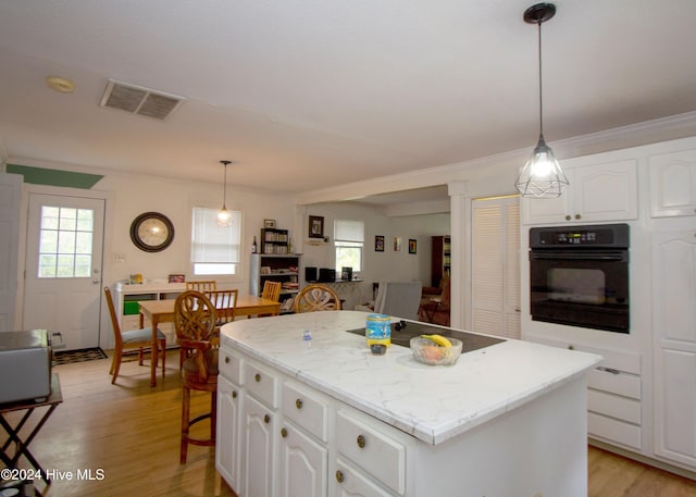 kitchen featuring white cabinets, a kitchen island, and black appliances