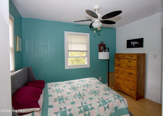 bedroom featuring light wood-type flooring, electric panel, and ceiling fan