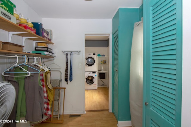 washroom featuring light hardwood / wood-style floors and stacked washer and clothes dryer