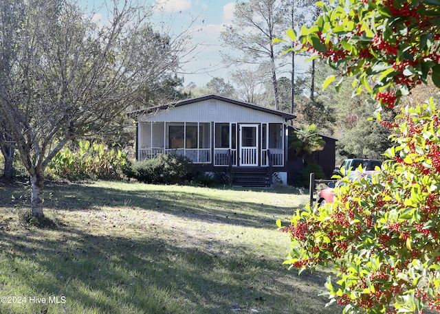 view of front of property with a sunroom and a front yard