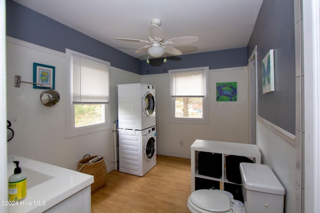 bathroom with stacked washer and dryer, plenty of natural light, hardwood / wood-style flooring, and ceiling fan