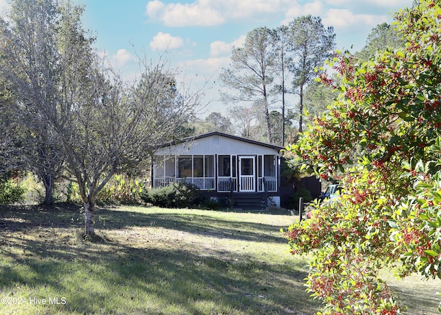 view of front of home with a front yard and a sunroom