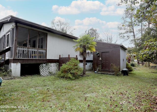 view of side of property with a lawn and a sunroom