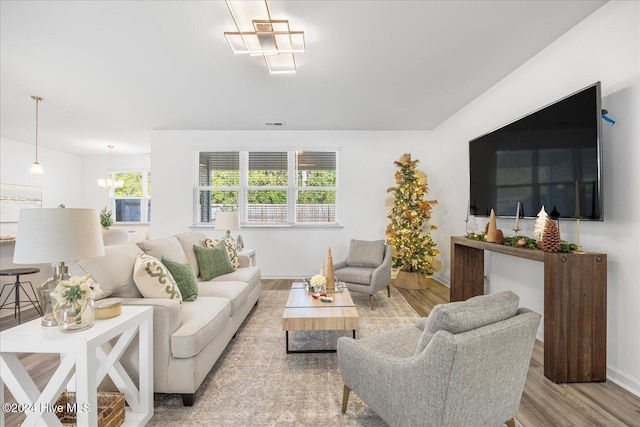 living room featuring light hardwood / wood-style floors, an inviting chandelier, and plenty of natural light