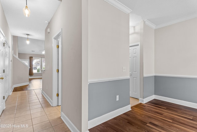 hallway featuring crown molding and light tile patterned floors