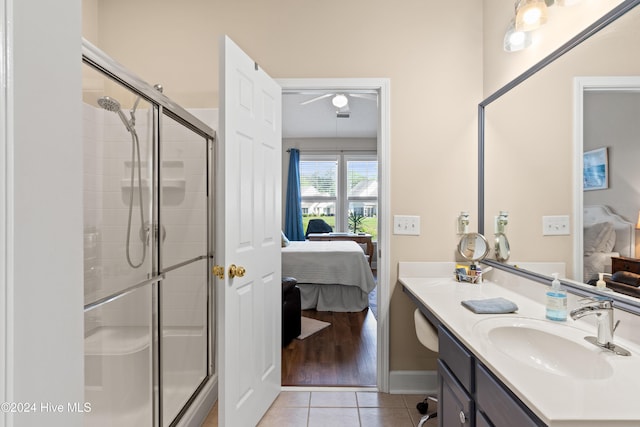 bathroom featuring tile patterned floors, a shower with door, and vanity