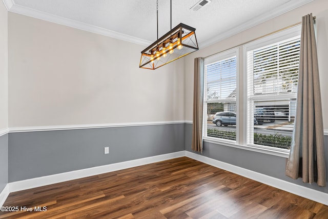 empty room featuring crown molding, dark wood-type flooring, and a textured ceiling