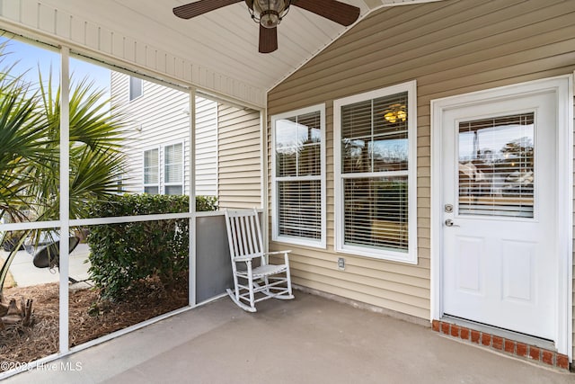 unfurnished sunroom with ceiling fan and vaulted ceiling