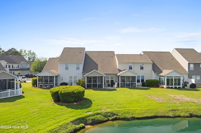 rear view of property featuring a yard and a sunroom