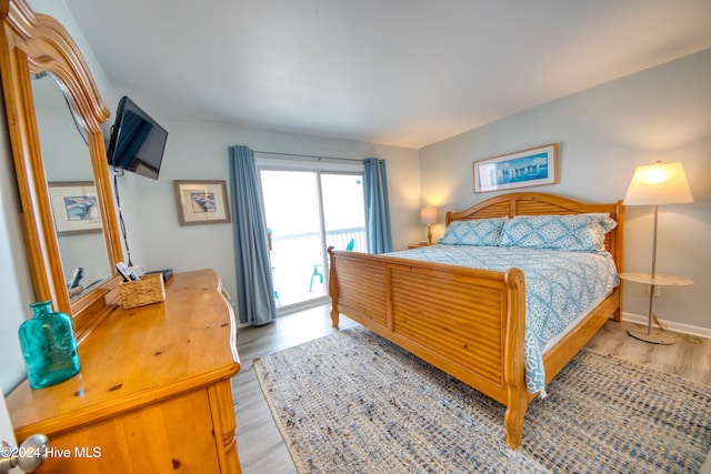 bedroom with access to exterior and light hardwood / wood-style flooring