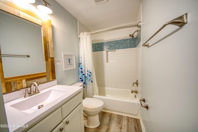 full bathroom featuring wood-type flooring, vanity, shower / tub combo, and toilet