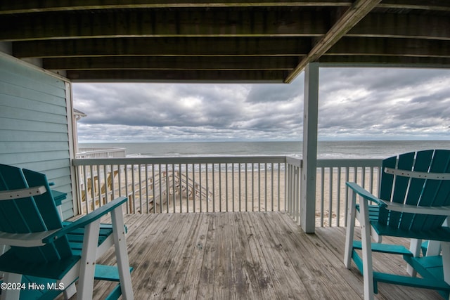 deck featuring a beach view and a water view