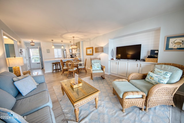 living room featuring a chandelier and light hardwood / wood-style flooring