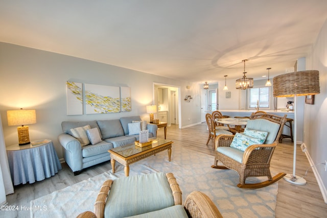 living room featuring a chandelier and light hardwood / wood-style flooring