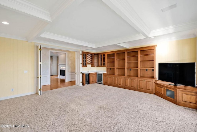 unfurnished living room featuring beam ceiling, light colored carpet, and ornamental molding